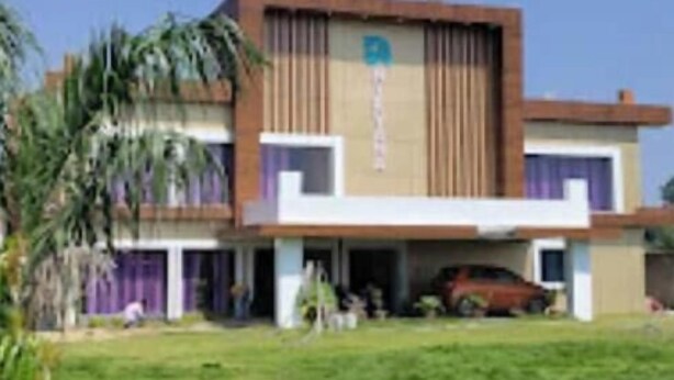 A two-story building with a flat roof, a central entrance, and a parking area with a red car. - The Nirvana Resort (Chatra)