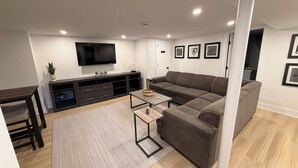 Ett modernt vardagsrum med en soffa, en tv och ett underhållningscenter.