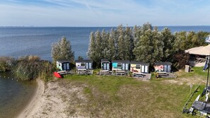 A lakeside camp with cabins, a beach, and a forested area.