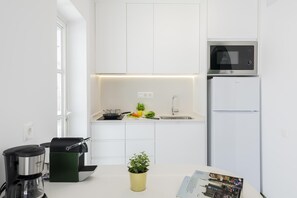 A modern kitchen with white cabinetry, a microwave, a coffee maker, and a sink. - Campo Golf 9 by VillaGranCanaria (Maspalomas)