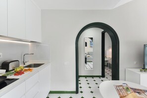 Eine moderne Küche mit eingebautem Toaster, einer Spüle und einer Arbeitsfläche mit frischem Obst und Gemüse.