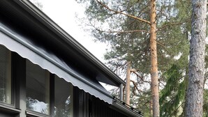 A deck with a sofa, a chair, and a small table. - Room-cozy City Cottage With Sauna, hot t (Espoo)