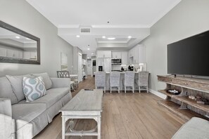 A modern living room with a sofa, coffee table, and TV stand. - 🐚Walk to Beach | Pool | Henderson Beach Resort Lofts 104- Poolside Paradise🐬 (Destin)