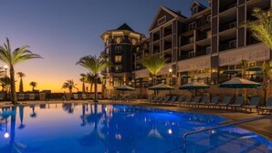 A hotel with a pool, lounge chairs, and umbrellas. - 🐚Walk to Beach | Pool | Henderson Beach Resort Lofts 411 Rooftop Retreat🐬 (Destin)
