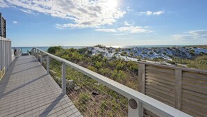 A wooden boardwalk leading to a beach with a clear sky and sun. - 🐚Walk to Beach | Pool | Henderson Beach Resort Lofts 411 Rooftop Retreat🐬 (Destin)