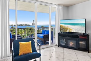 Ein Balkon mit Fernseher, einer Couch und einem Kamin.