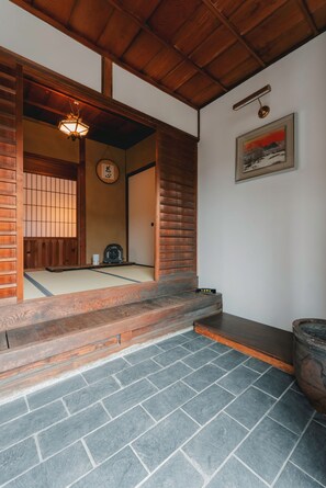 Een traditionele Japanse kamer met tatami vloeren, een houten plafond en een schuifdeur.