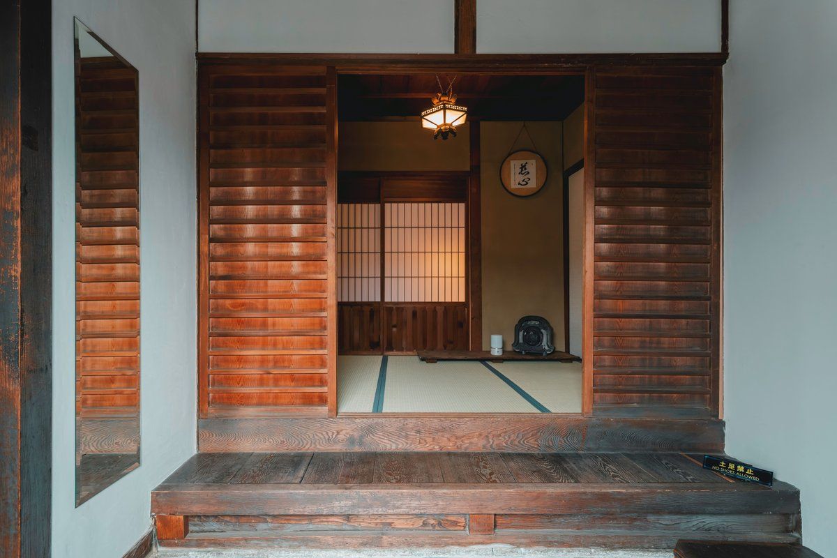 Un intérieur japonais traditionnel avec des portes coulissantes en bois, un sol recouvert de tatamis et une lanterne.