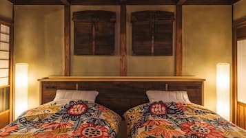 A room with two beds, wooden headboards, and a wooden ceiling.