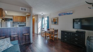Espai habitable compacte amb cuina, zona de dinar i televisió.
