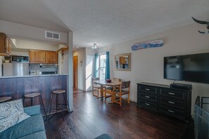 A compact living space with a kitchen, dining area, and a TV. - Condo close to hiking trails and base area (Angel Fire)