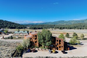 A lodge with a large central building, multiple smaller structures, and a parking area. - Condo close to hiking trails and base area (Angel Fire)