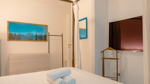 Een hotelkamer met een bed, een schilderij, een spiegel, een televisie en een kledingkast.
