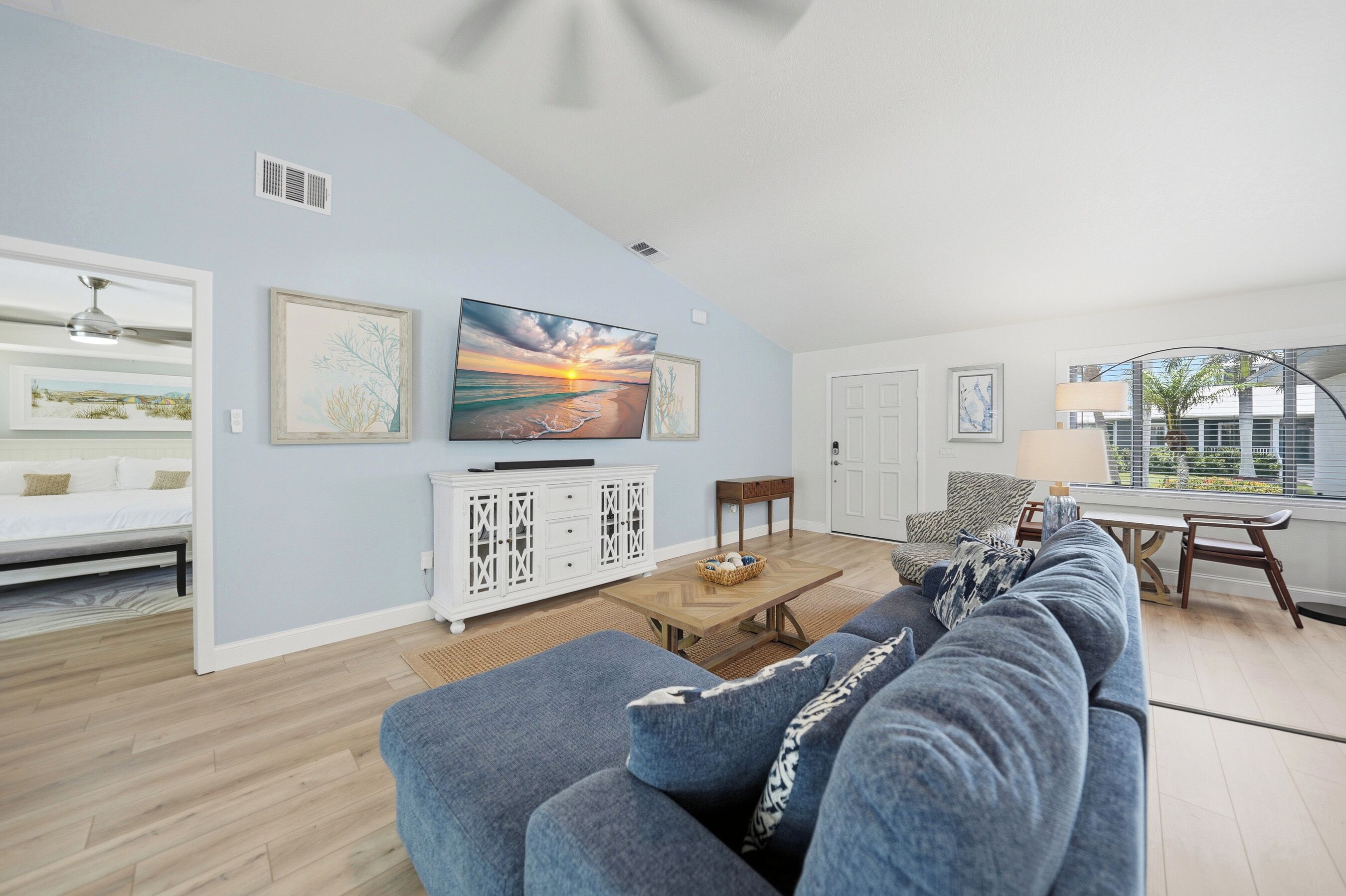 A living room with a sofa, a coffee table, a TV, and artwork on the wall.