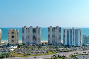 Ein hoch aufragendes Hotel an der Küste mit mehreren Etagen, einem Parkplatz und Blick auf den Ozean.