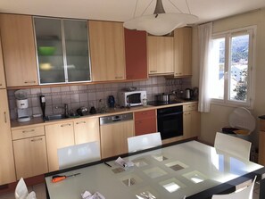 Una cocina moderna con armarios de madera, microondas, cafetera y lavavajillas.