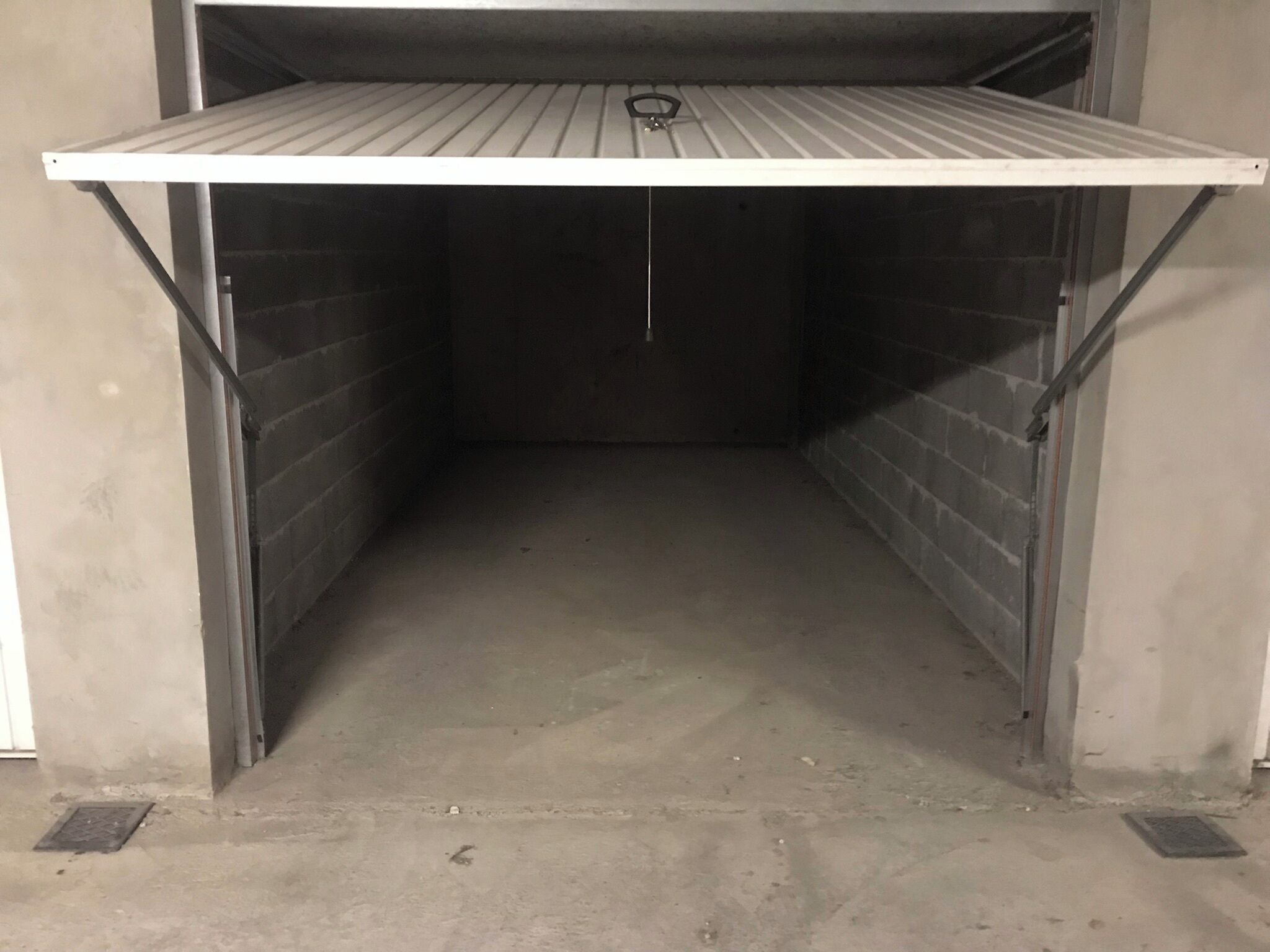 A storage space with metal shelving and a concrete floor.
