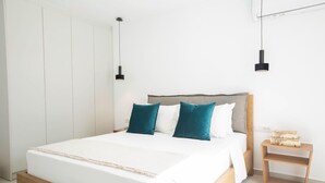 A modern bedroom with a bed, bedside tables, and a wardrobe. - Amalfi Twins Villa A (Nydri)