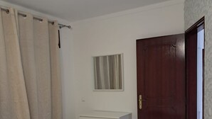 A bedroom with a bed, a dresser, a door, and a window. - T2 VISTA MAR in Quarteira (Quarteira)