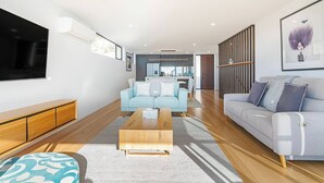Una sala de estar moderna con un sofá, una mesa de centro y un televisor.