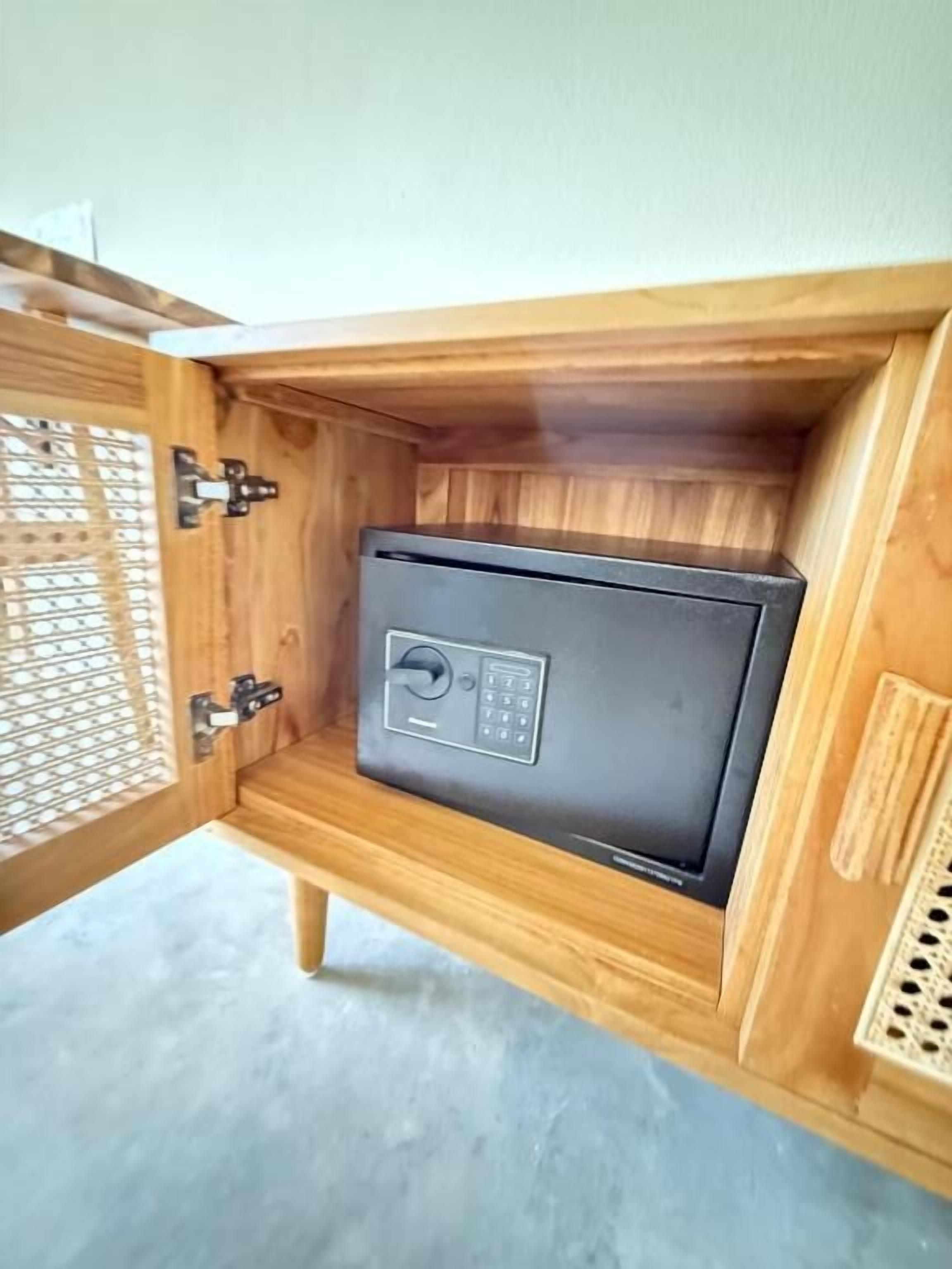A wooden cabinet with a black safe inside.