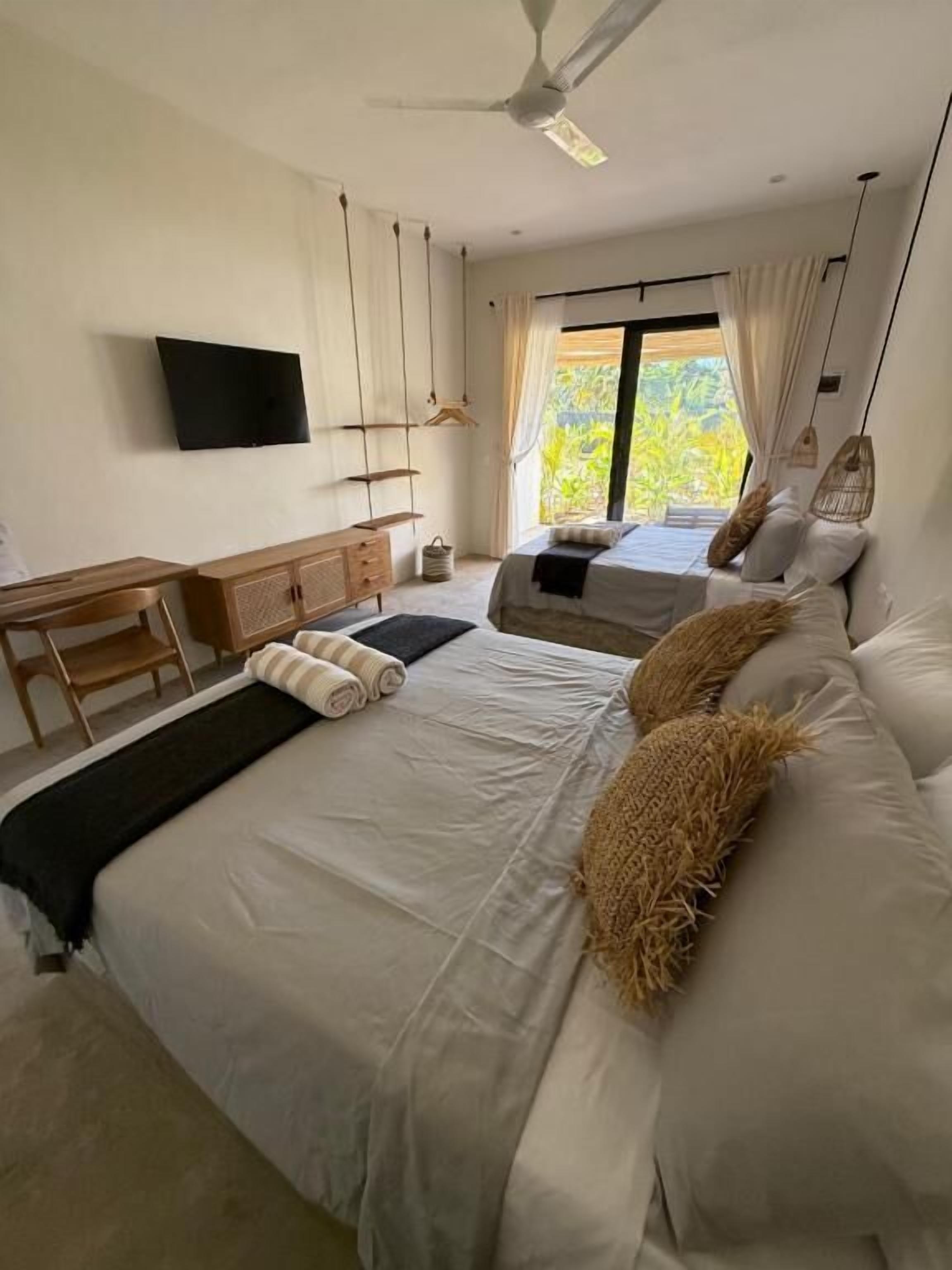 Vierpersoonskamer, terras, uitzicht op tuin | Een kluis op de kamer, een bureau, verduisterende gordijnen