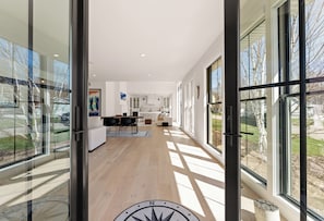 Ein modernes Interieur mit einer Küche, einem Essbereich und großen Fenstern.