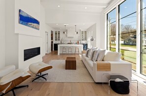 Ein modernes Wohnzimmer mit einem weißen Sofa, einem Couchtisch und einem an der Wand montierten Fernseher.