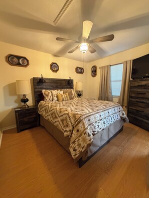 A bedroom with a bed, nightstands, a ceiling fan, a TV, and decorative wall plates. - Beautiful 2 bedroom condo close toGolf courses and the Sebring race track (Sebring)