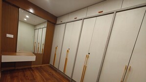 A room with wooden flooring, a mirror, and a wardrobe with sliding doors. - Cozy Wood Paneled Scenic Room with Walk-in Closet (Manali)