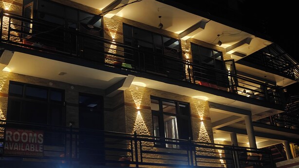 A multi-story building with balconies, a 'Rooms Available' sign, and a 'No Parking' sign. - Cozy Wood Paneled Scenic Room with Walk-in Closet (Manali)