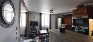 A kitchen with a dining area, a large mirror, and a built-in oven.
