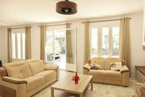 Ein Wohnzimmer mit zwei Sofas, einem Couchtisch und einer Deckenleuchte.