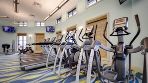 Ein Fitnessraum mit Laufbändern, Crosstrainern und einem stationären Fahrrad.