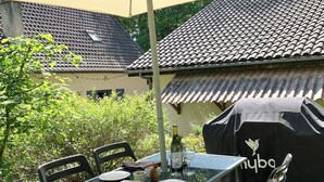 An outdoor dining area with a table, chairs, and a covered grill. - Small cottage in the woods with private pool (Saint-Jean-d'Estissac)