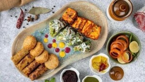 Une assiette contenant divers aliments, notamment de la viande grillée, des légumes et des sauces.