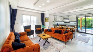 A modern living room with a sofa, armchairs, and a coffee table.