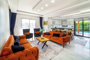 A modern living room with a sofa, armchairs, and a coffee table.