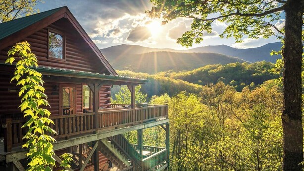 Eine Hütte mit einer Terrasse und Bergblick.
