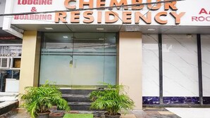 L’entrée d’un hôtel, avec une enseigne indiquant « CHEMDRY RESIDENCY ».