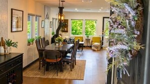 A modern kitchen with a dining area, wooden flooring, and a decorative plant arrangement. - Serene Andes Retreat: A/C, BBQ & Nature (Andes)