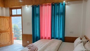 A bedroom with a bed, curtains, and a wooden door.