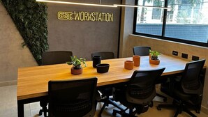 A conference room with a long table, black chairs, potted plants, and a wall with a sign that reads 'GATE WORKSTATION'. - Flat Beira mar João Pessoa (João Pessoa)