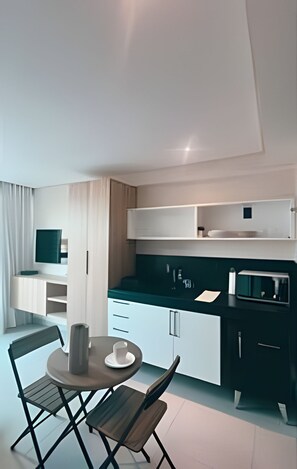 A modern kitchen with a dining area, including a table with chairs, a microwave, and cabinets. - Flat Beira mar João Pessoa (João Pessoa)