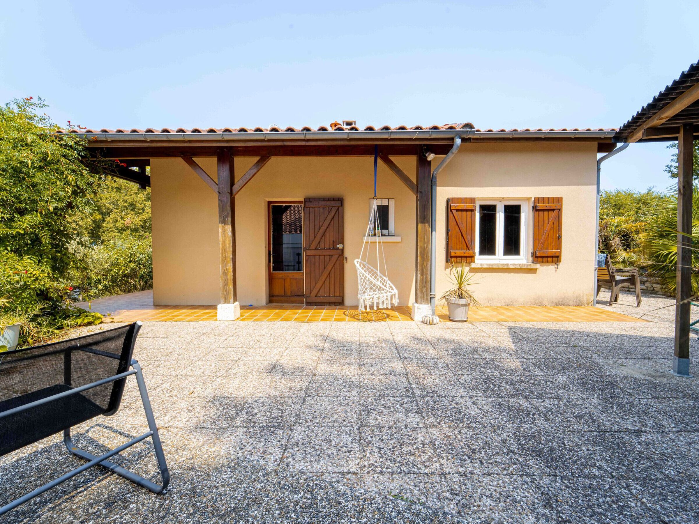 A house with a tiled roof, a wooden door, and a covered porch area.