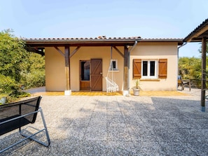 Una casa con tetto in tegole, una porta in legno e un portico coperto.
