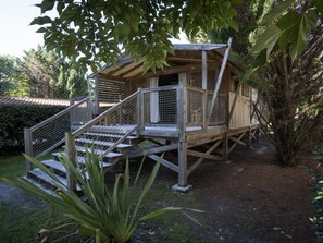 Une cabane en bois avec un escalier et un balcon entouré d’une balustrade.