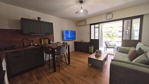 Un espacio de estar moderno con cocina, comedor y zona de descanso.