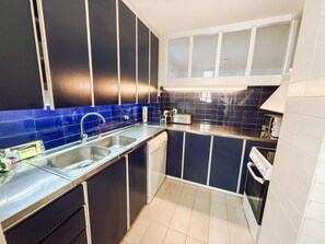 A compact kitchen with a sink, a toaster, and a microwave. - Spacious apartment with sea view - 6 guests (Platja d'Aro)