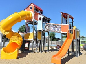 Ein Spielplatz mit Rutschen und Klettergerüsten.